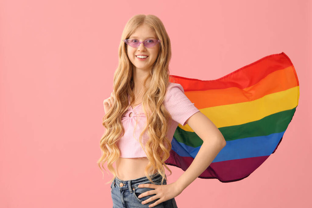 Όμορφη νεαρή ευτυχισμένη γυναίκα με ΛΟΑΤ σημαία σε ροζ φόντο - Φωτογραφία, εικόνα