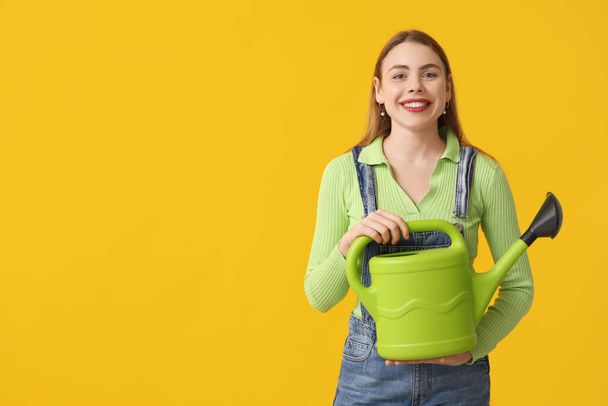 Щаслива молода жінка з лійкою може на жовтому тлі - Фото, зображення