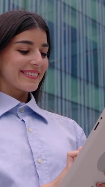 Vertical 9: 16 retrato de uma mulher de negócios de sucesso usando tablet digital sobre edifício empresarial moderno corporativo. Vídeo em tela HD. - Filmagem, Vídeo