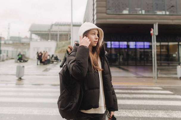 Turista tizenéves lány utazik egyedül a város utcáin az őszi-téli szezonban. Modern egyéni utazás, magányos utazó, Téli nyaralás vasút kaland koncepció. - Fotó, kép