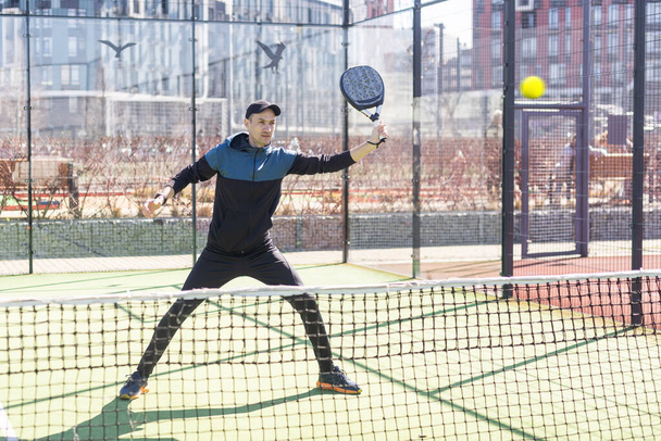 Πορτρέτο ενός ευρωπαίου παίκτη padel τένις παίζει στο εξωτερικό γήπεδο. Υψηλής ποιότητας φωτογραφία - Φωτογραφία, εικόνα