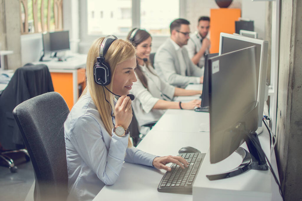 Agentes de atendimento ao cliente com fone de ouvido trabalhando em um call center - Foto, Imagem
