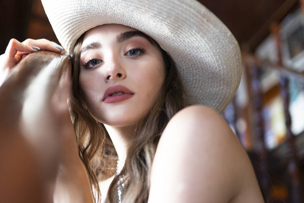 bella giovane donna in cappello di paglia rilassante su una terrazza estiva  - Foto, immagini
