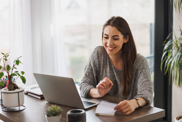 Молода жінка-підприємець зустрічається онлайн з її домашнього офісу. - Фото, зображення