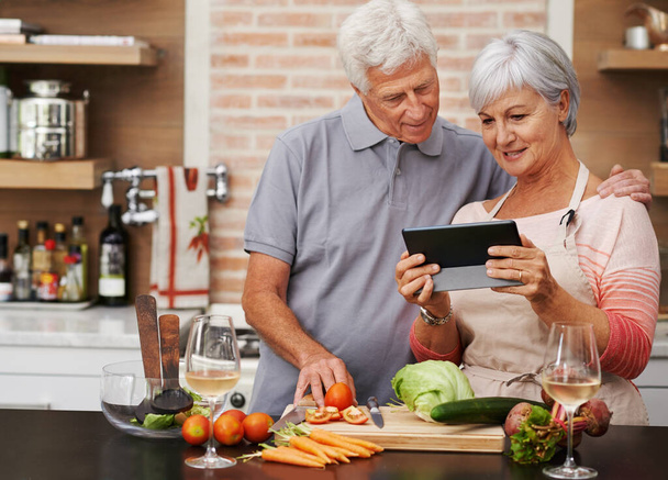 Senior couple, tablet and vegetables for cooking wholesome, healthy and nutritional food at home. Husband, wife and digital device for researching ingredients, recipes and delicious vegan meals. - Photo, Image