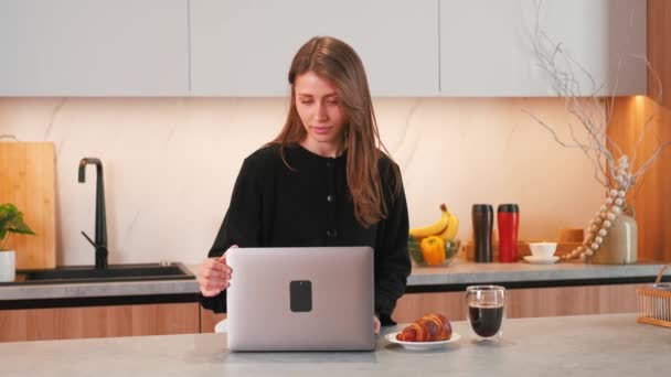 Felvétel fiatal nő nyitja laptopját konyhaasztalnál. - Felvétel, videó