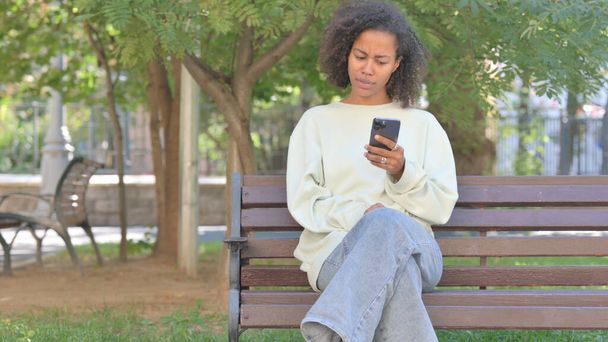 Casual African Woman Shocked by Loss on Phone Outdoor - Photo, Image