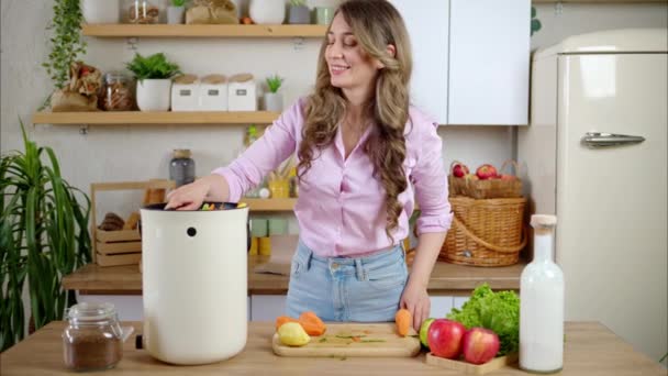 Frau recycelt Biomüll, indem sie Gemüseschalen in der Küche kompostiert - Filmmaterial, Video