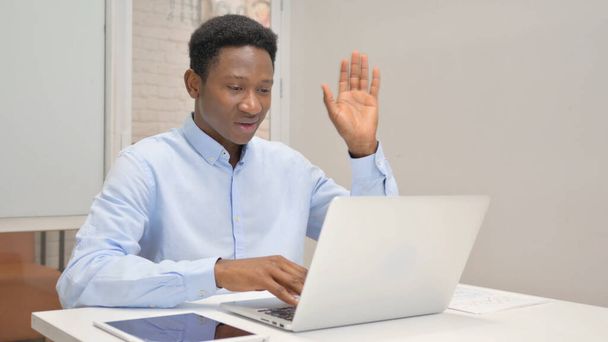 Африканский бизнесмен в чате онлайн на ноутбуке во время работы в офисе - Фото, изображение