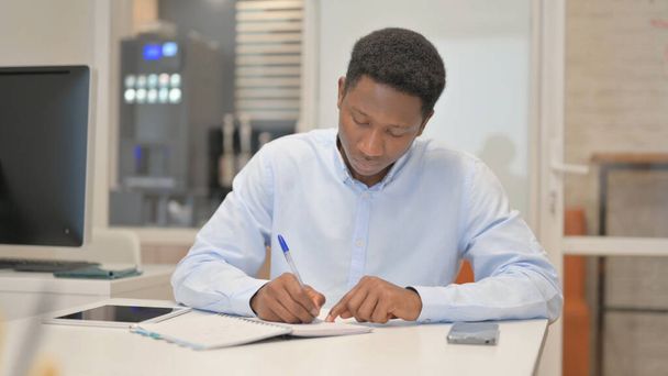 Afrikanischer Geschäftsmann schreibt Brief im Amt - Foto, Bild