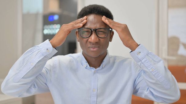 Portret afrykańskiego biznesmena z bólem głowy w biurze - Zdjęcie, obraz