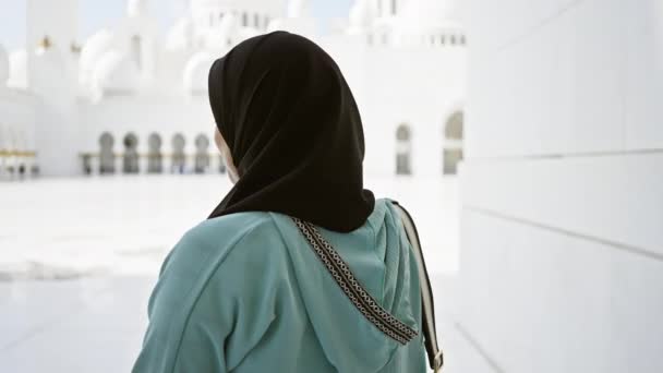 Улыбающаяся женщина в хиджабе наслаждается безмятежной красотой великой мечети Абу-Даби. - Кадры, видео