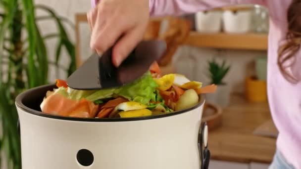 Жінка переробляє органічні відходи шляхом компостування пілінгів овочів на кухні - Кадри, відео