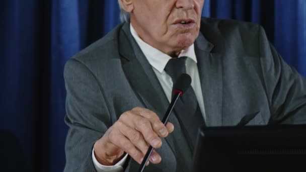 Напружений знімок старшого сенатора, що стоїть на лекції з мікрофоном і виступає під час політичної прес-конференції - Кадри, відео