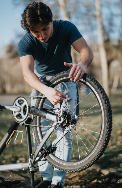 Centrado en la reparación individual de un neumático de bicicleta al aire libre, mostrando autosuficiencia y habilidades para resolver problemas. - Foto, imagen