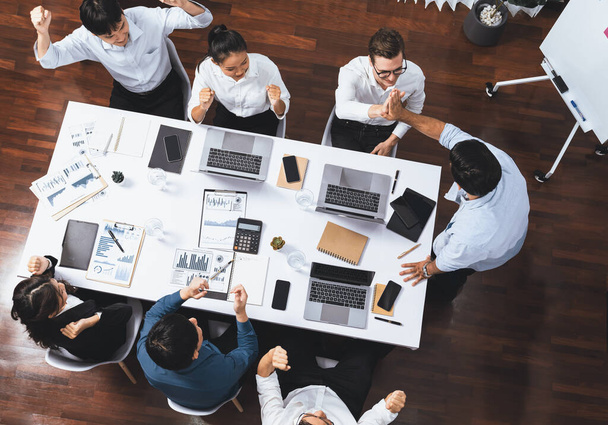 Top view diverse kantoormedewerker high five na het maken van overeenstemming over strategische business marketing planning. Teamwork en positieve houding creëren een productieve en ondersteunende werkplek. Prudent - Foto, afbeelding