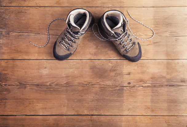 Hiking shoes on a wooden floor - Fotó, kép