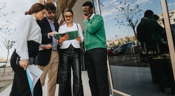A diverse group of start-up entrepreneurs discussing business plans outside a modern office building. - Φωτογραφία, εικόνα