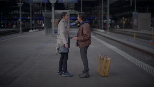 Pożegnanie dwojga smutnych ludzi opuszczających dworzec kolejowy - Materiał filmowy, wideo