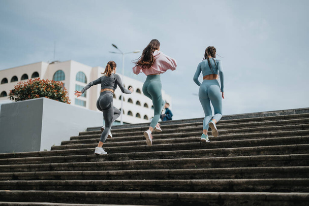 Vista posterior de mujeres activas en ropa deportiva trotando pasos concretos como parte de su rutina de entrenamiento. - Foto, imagen