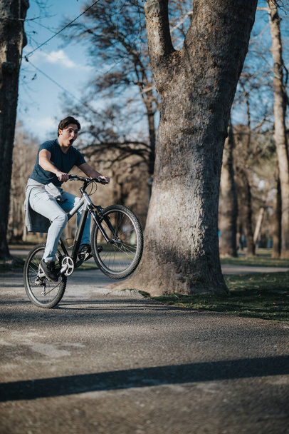 Piacevole giro in bicicletta catturato in un tranquillo parco con alberi abbondanti e sole. - Foto, immagini