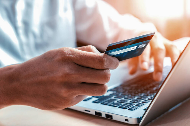 Nuori mies käyttää luottokorttia ostoksia varten maksu verkossa kannettavan tietokoneen sovellus tai verkkosivuilla. Sähköinen kaupankäynti ja verkkokaupan käsite. Uudit - Valokuva, kuva