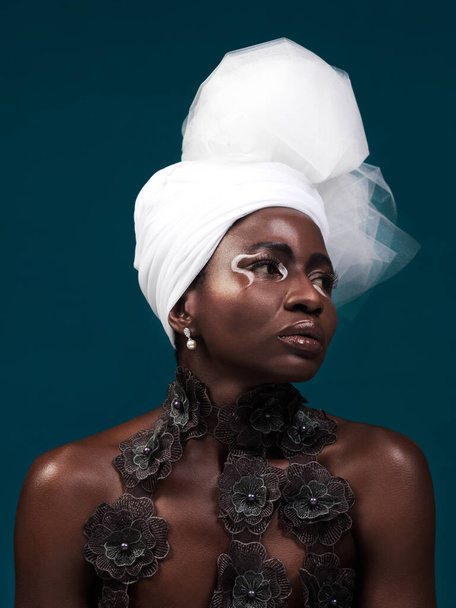 Beauty, fashion and black woman in makeup with headwrap.in studio isolated on a blue background. African model, cosmetics and head scarf with serious face for traditional style, elegance or thinking. - Photo, Image