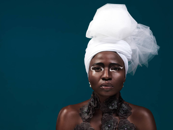 Piękno, moda i portret czarnej kobiety w turban i makijaż w studio odizolowane na niebieskim tle makiety. Afrykański model, kosmetyki i apaszka na głowę z poważną twarzą dla tradycyjnego stylu w Kenii. - Zdjęcie, obraz