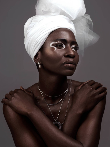 Thinking, wrap and black woman with makeup, beauty and confidence on dark studio background. Face, turban and African model with traditional outfit, eyeshadow cosmetics and necklace for culture pride. - Photo, Image