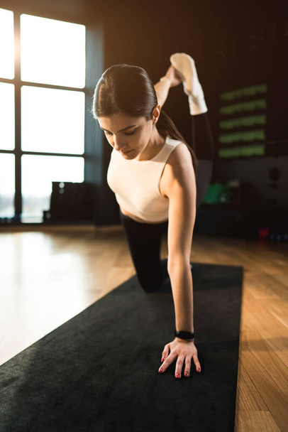 Genç atletik kadın spor salonunda yoga yapıyor. Yoga ve spor. Sağlıklı yaşam tarzı konsepti. - Fotoğraf, Görsel