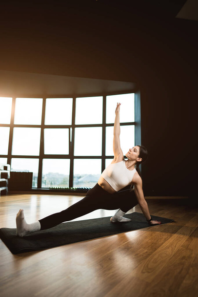 Mujer atlética joven se dedica al fitness y hace yoga en el gimnasio.Yoga y fitness.Healthy concepto de estilo de vida - Foto, imagen