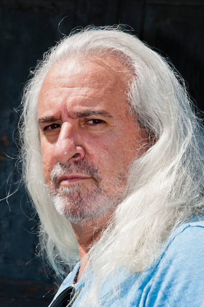 Hispánec senior zralé sebevědomý muž s neoholenou tváří a šedé dlouhé zdravé vlasy zářící v létě venkovní portrét. - Fotografie, Obrázek