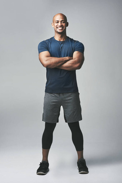 Μαύρος άνδρας, πορτραίτο και μπράτσα σταυρωμένα στο studio για fitness, δυνατά και αθλητικά ρούχα για προπόνηση ή προπόνηση. Άνδρας, αθλητής και υπερηφάνεια για την πρόοδο σε γκρι φόντο, φροντίδα και πρόκληση του σώματος. - Φωτογραφία, εικόνα