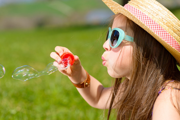 a little girl making soap bubbles  - Photo, Image