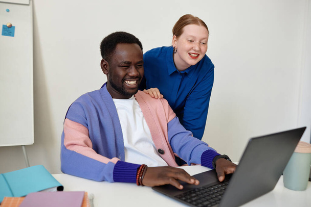 Ritratto del team di progettazione creativa con uomo nero che utilizza il computer portatile e sorride in ufficio, copia lo spazio - Foto, immagini