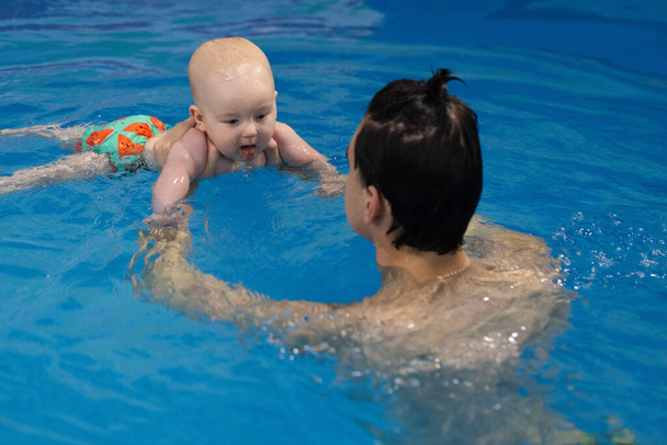 水の下でダイビングした後に咳をする赤ちゃん. 新生児と水中のダイビングのレッスン - 写真・画像