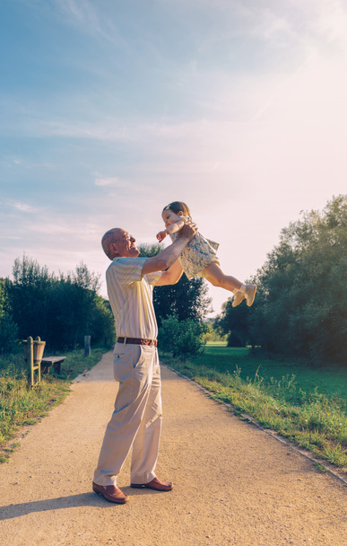 Senior homme jouer avec bébé fille en plein air
 - Photo, image