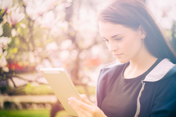 Beautiful girl with tablet or ebook outdoor - 写真・画像