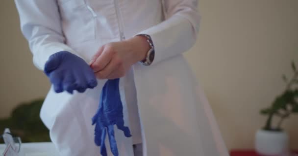 El médico se pone guantes y se prepara para los exámenes de sus pacientes.. - Imágenes, Vídeo