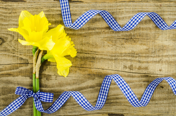 Ahşap masa üzerinde mavi kurdele ile çiçek - Fotoğraf, Görsel