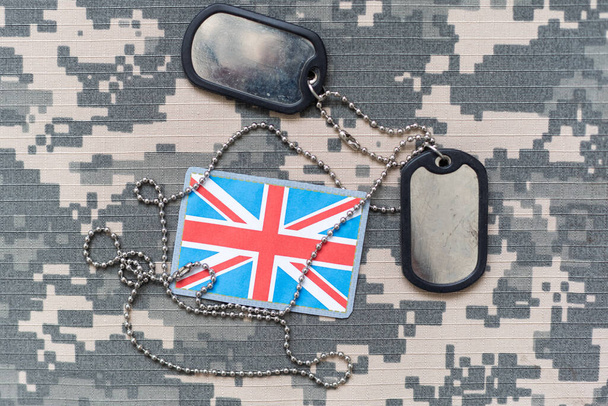army blank, dog tag with flag of great britain on the khaki texture background. military concept. High quality photo - Photo, Image