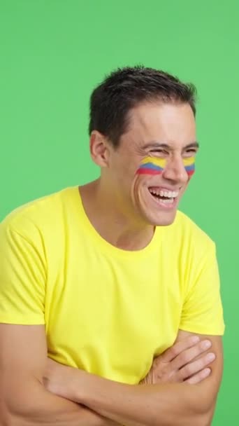 Vidéo en studio avec chroma d'un homme heureux avec drapeau colombien peint sur le visage regardant loin de l'espace de copie en blanc - Séquence, vidéo