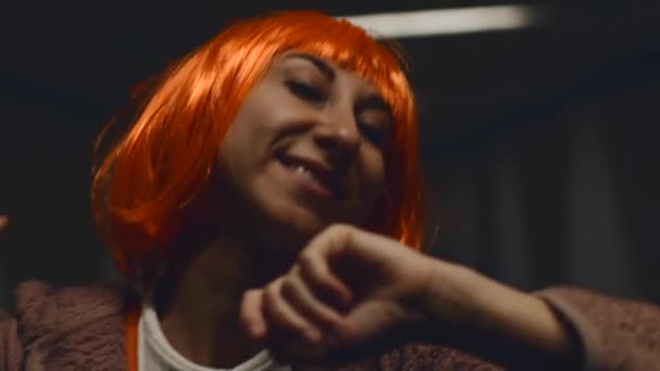 Meisjes dansen. stijlvolle jonge vrouw met oranje haren danst in een nachtclub. Muziek, dansen en feesten met vrouwen tijdens het concert. - Video