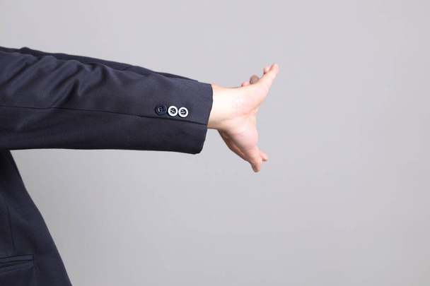 Азіатський бізнесмен з формальним одягом з жестом виснаженого на сірому фоні. - Фото, зображення