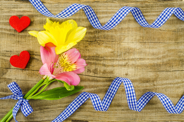 Λουλούδι με μπλε κορδέλα στο ξύλινο τραπέζι - Φωτογραφία, εικόνα