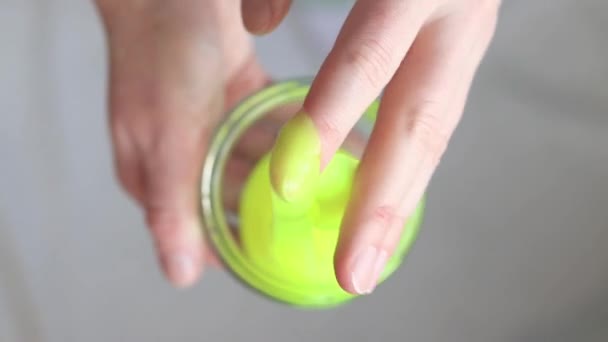 Girl kneads the yellow mucus. Woman's hands stretch bright yellow slime close-up. An anti-stress toy for relaxation, a way to take your mind off work or school. A fun sensory activity - Footage, Video