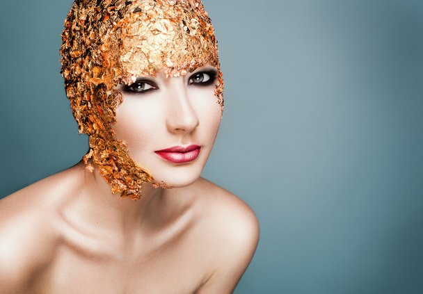 Close-up portrait girl model in a stylish gold foil.  - Photo, Image