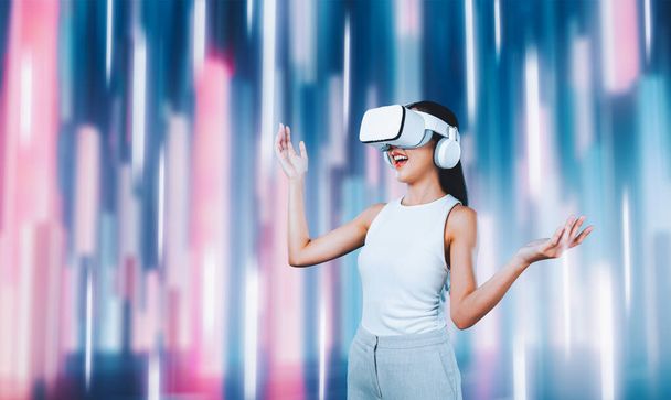 Nő áll és visel fehér VR headset és fehér ujjatlan csatlakozni metaverse, jövőbeli technológia létrehozása kibertér közösség. Szeret fantáziafényt nézni maga körül. Hallucináció. - Fotó, kép