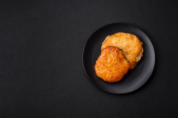 Νόστιμο κρέας τηγανισμένο με μουστάρδα Dijon με αλάτι, μπαχαρικά και βότανα σε σκούρο φόντο τσιμέντο - Φωτογραφία, εικόνα