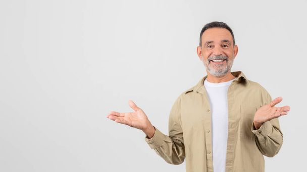 Starší muž se zářivým úsměvem a otevřenou náručí, který nabízí uvítací gesto izolované na bílém pozadí - Fotografie, Obrázek